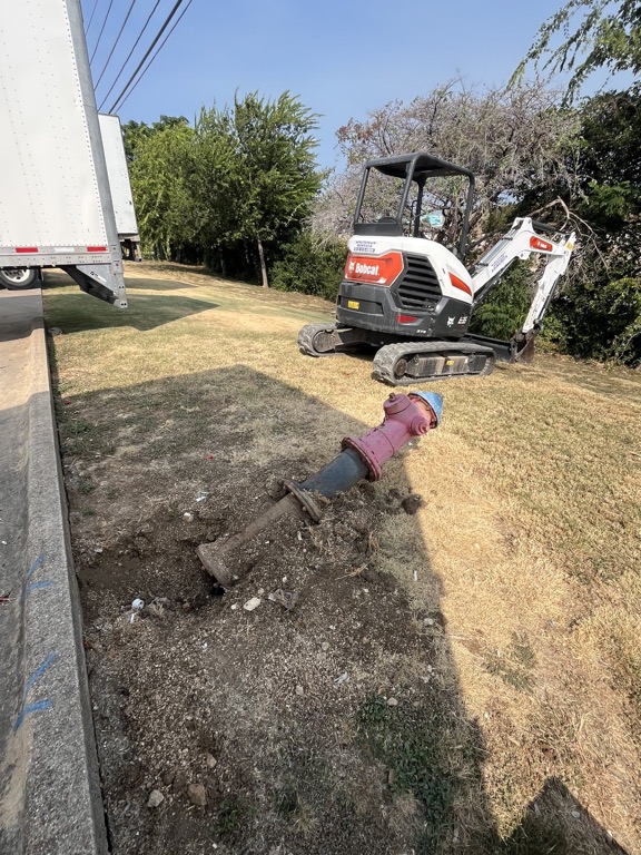 Existing private fire hydrant removed beside excavation equipment before replacement
