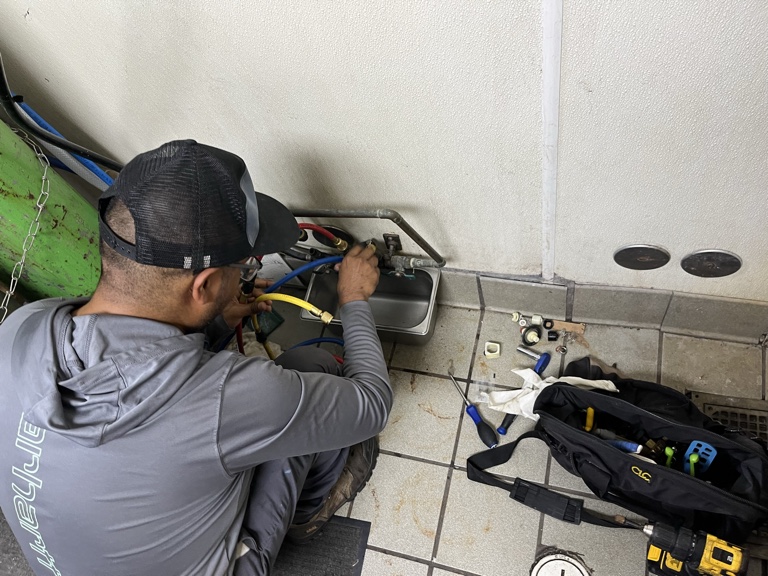 H2O technician servicing plumbing equipment