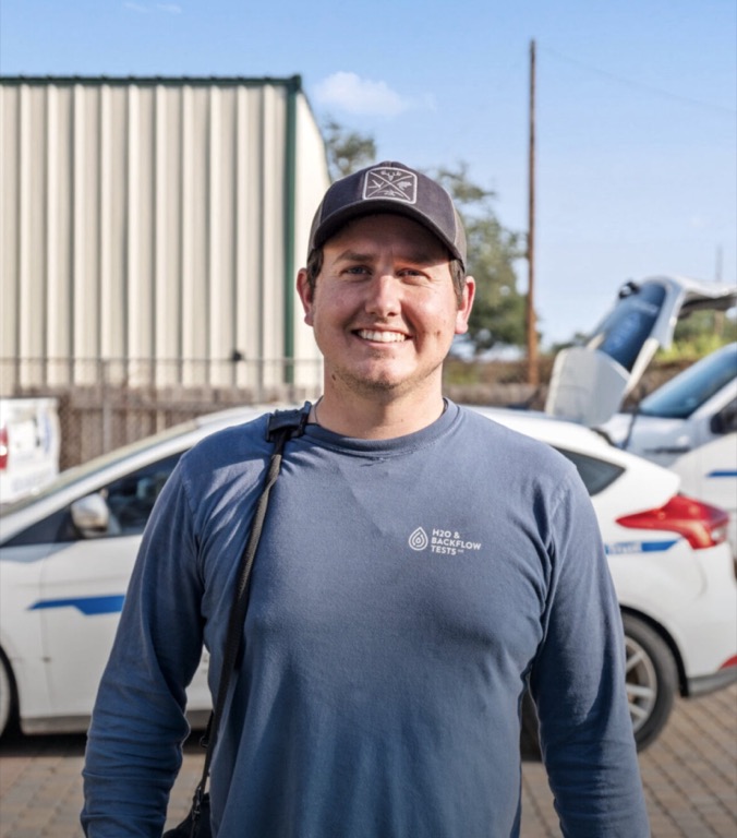 H2O technician in front of service vehicles