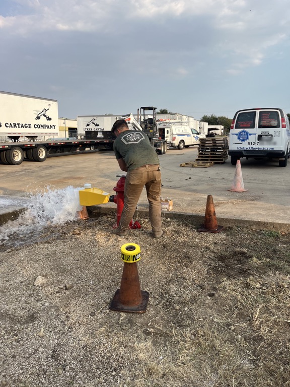 H2O technician operating a private hydrant during field flow verification in Central Texas