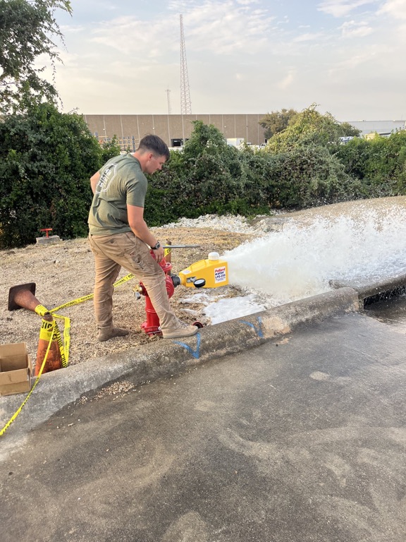 H2O technician performing a private fire hydrant flow test at a Central Texas commercial property