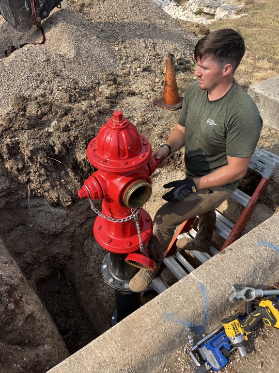 H2O technician setting a replacement private fire hydrant in an excavated connection