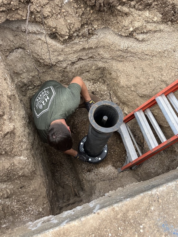 H2O technician fastening the underground hydrant riser connection